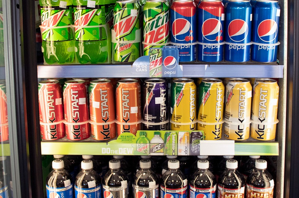 A Convenience Store display case with cold sodas and energy drinks, some of our Carriage Square, Oxnard drinks for beach trips.